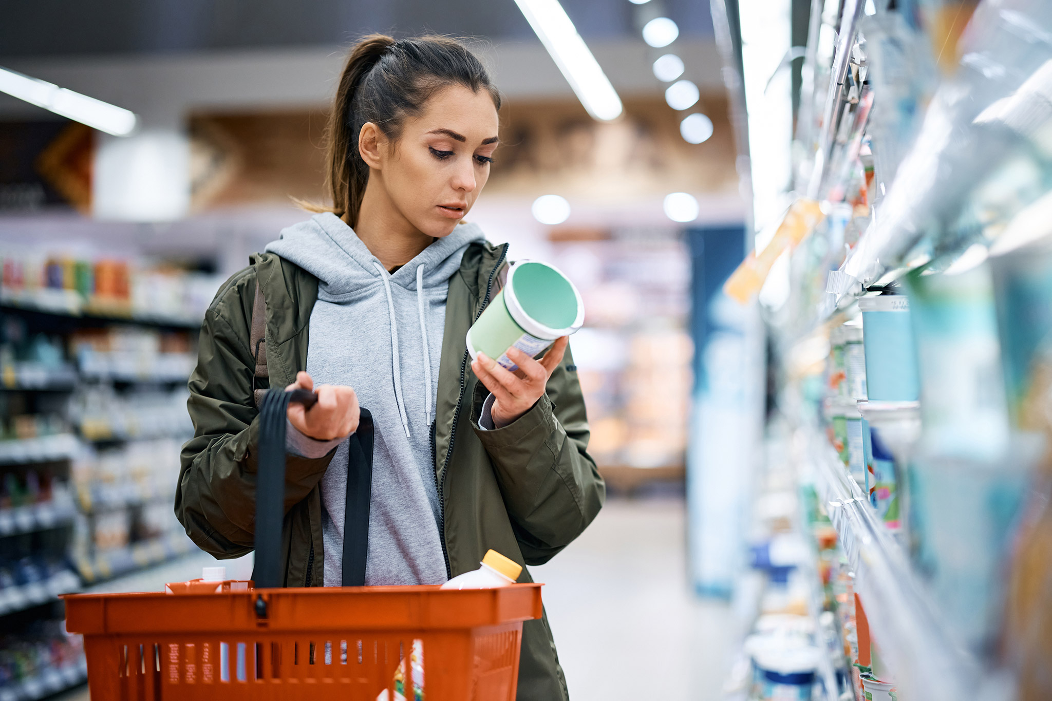 Frau liest im Supermarkt das Etikett